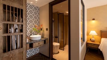 A hotel bathroom with a vanity, toilet, and shower.