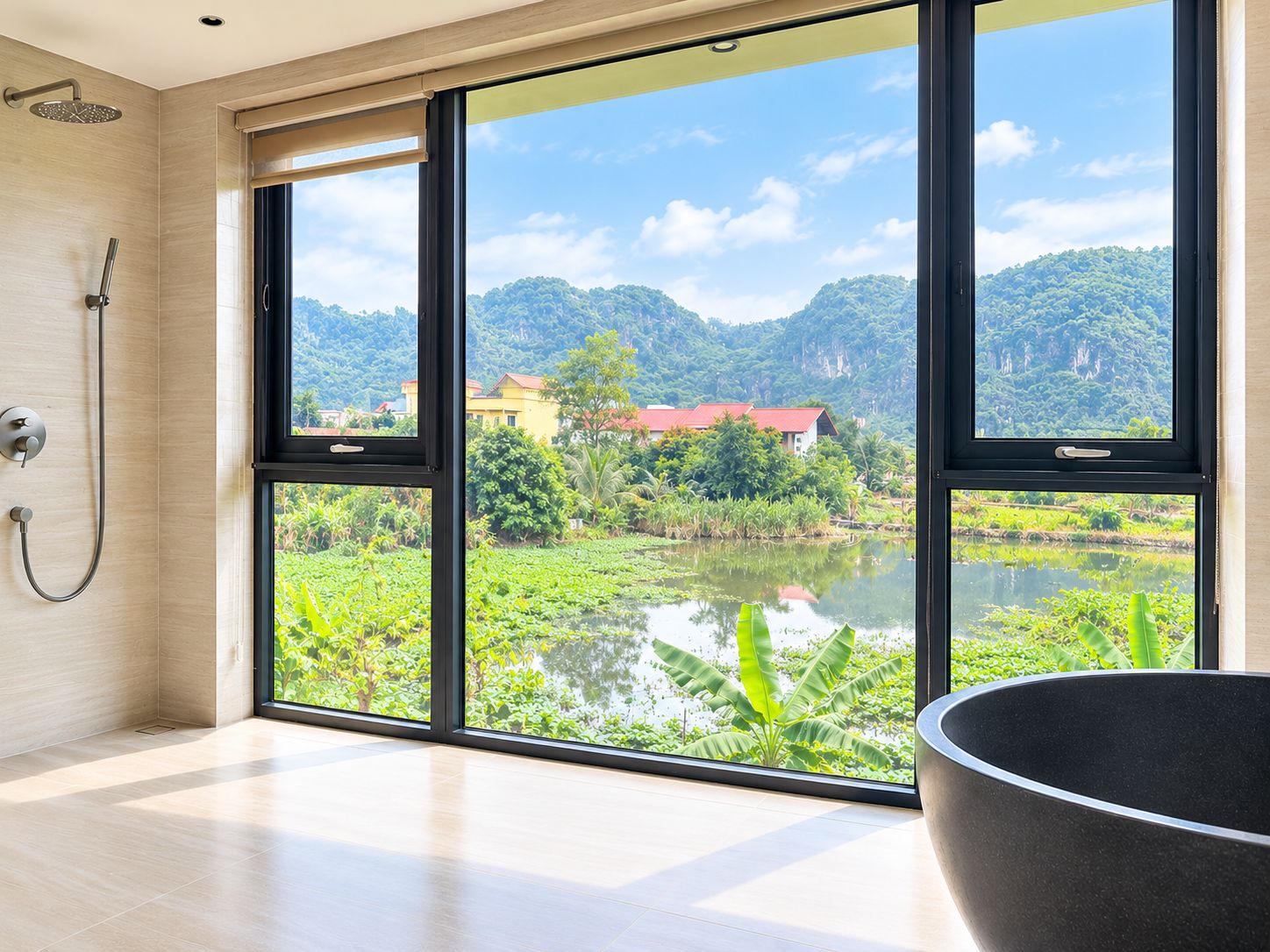 A bathroom with a large window, a shower, and a view of a lake and mountains.