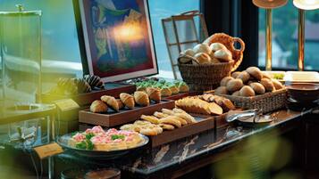 Una mesa de buffet con distintos alimentos y una obra de arte enmarco.