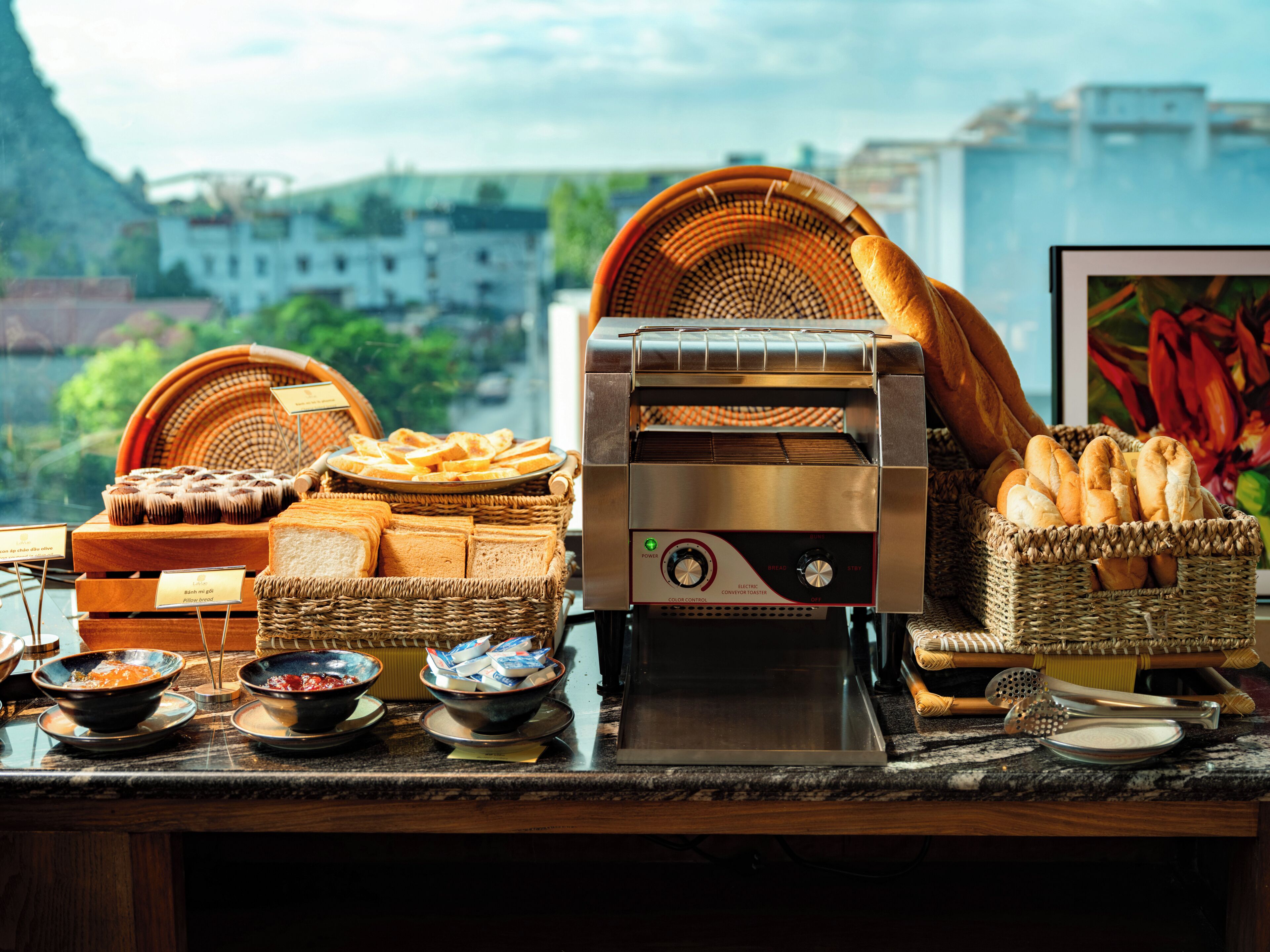 A kitchen counter with various bread and pastries, a toaster, and kitchen utensils.