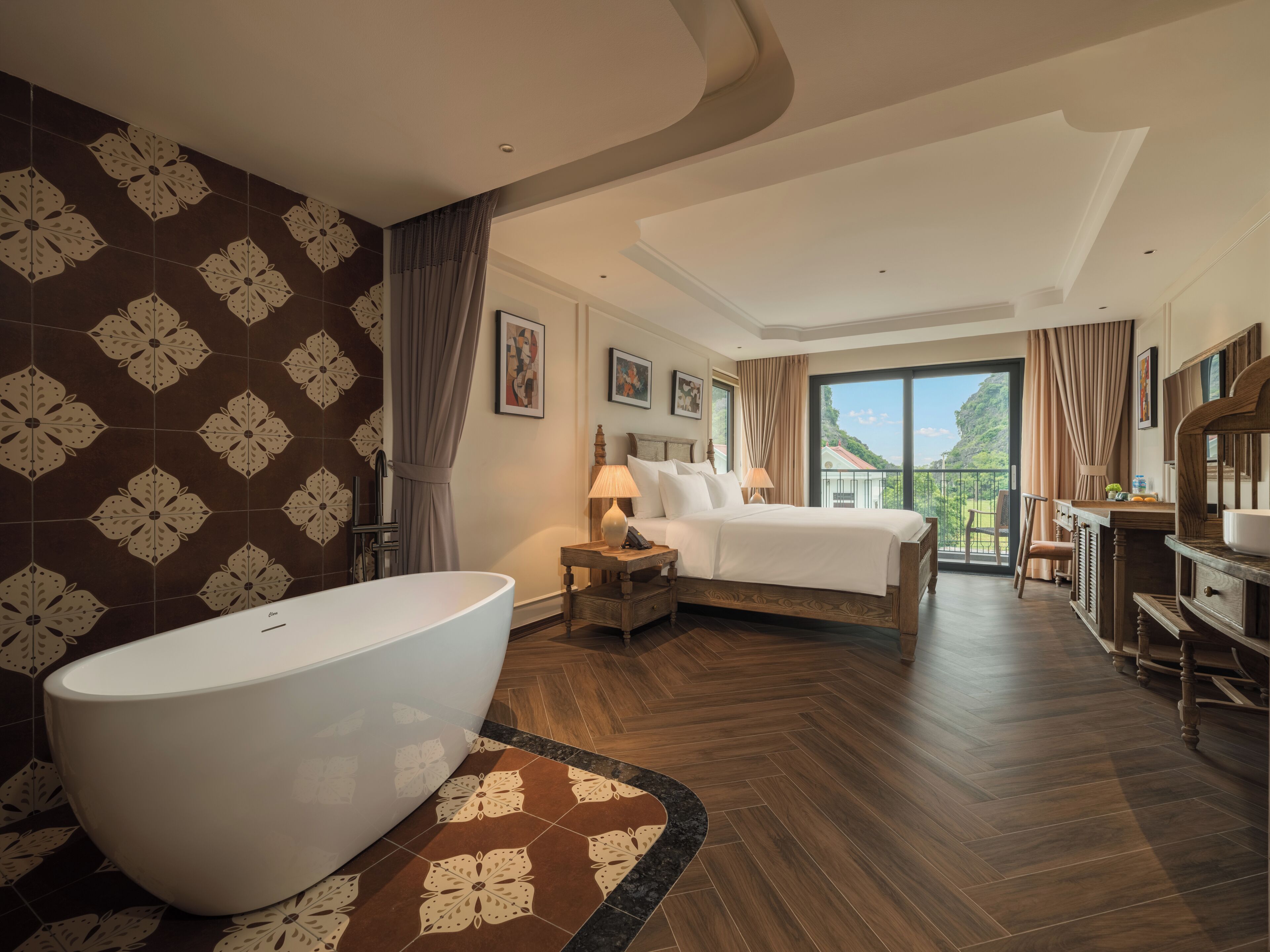 A hotel room with a large bathtub, a bed with a view to the outside, and a wooden vanity with a mirror.