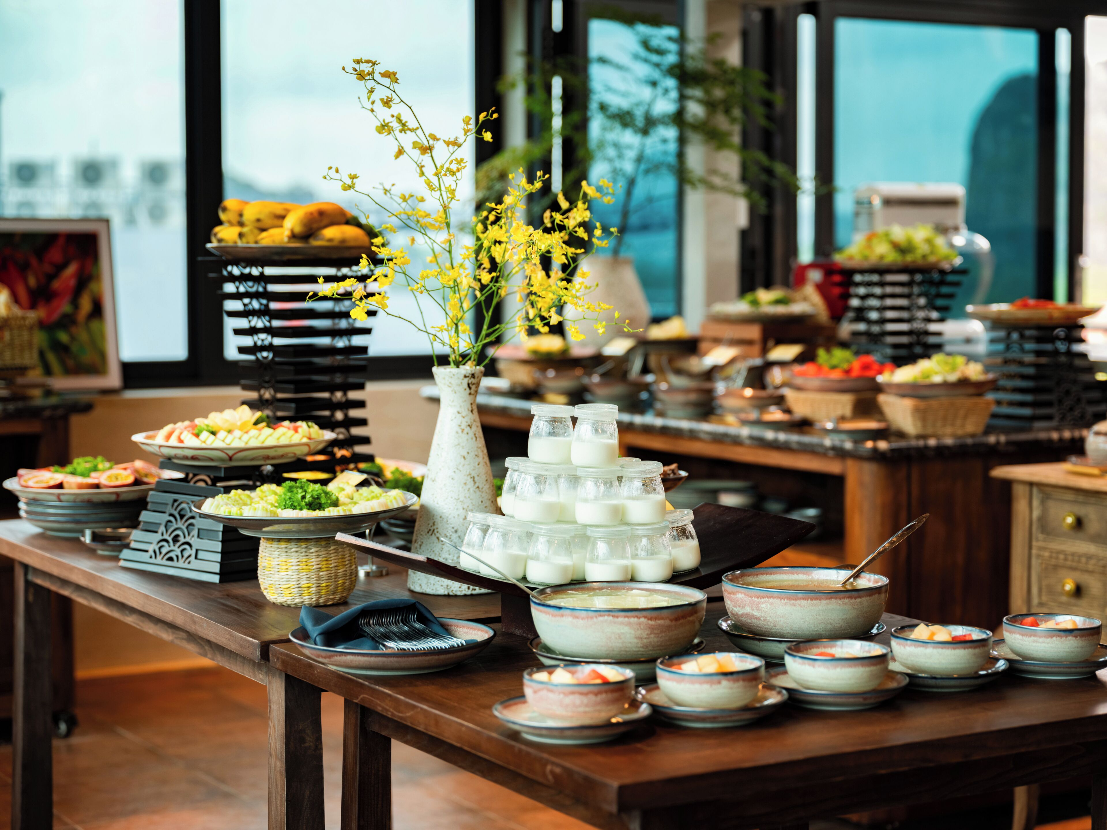 Una mesa de buffet con diferentes alimentos y un jarrón decorativo.