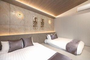 A hotel room with two beds, a marble wall, and a ceiling light. - JAPAVISTA Luminous (SHIMANOUCHI, CHUO WARD)