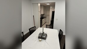 Een eetgedeelte met een tafel, stoelen en een decoratief middelpunt.