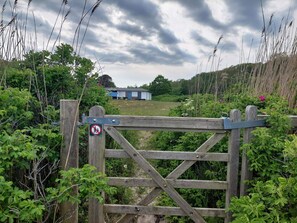 A wooden gate with a no-entry sign, surrounded by greenery and a building in the background. - 4 Star Holiday Home in Frederikshavn (Frederikshavn)