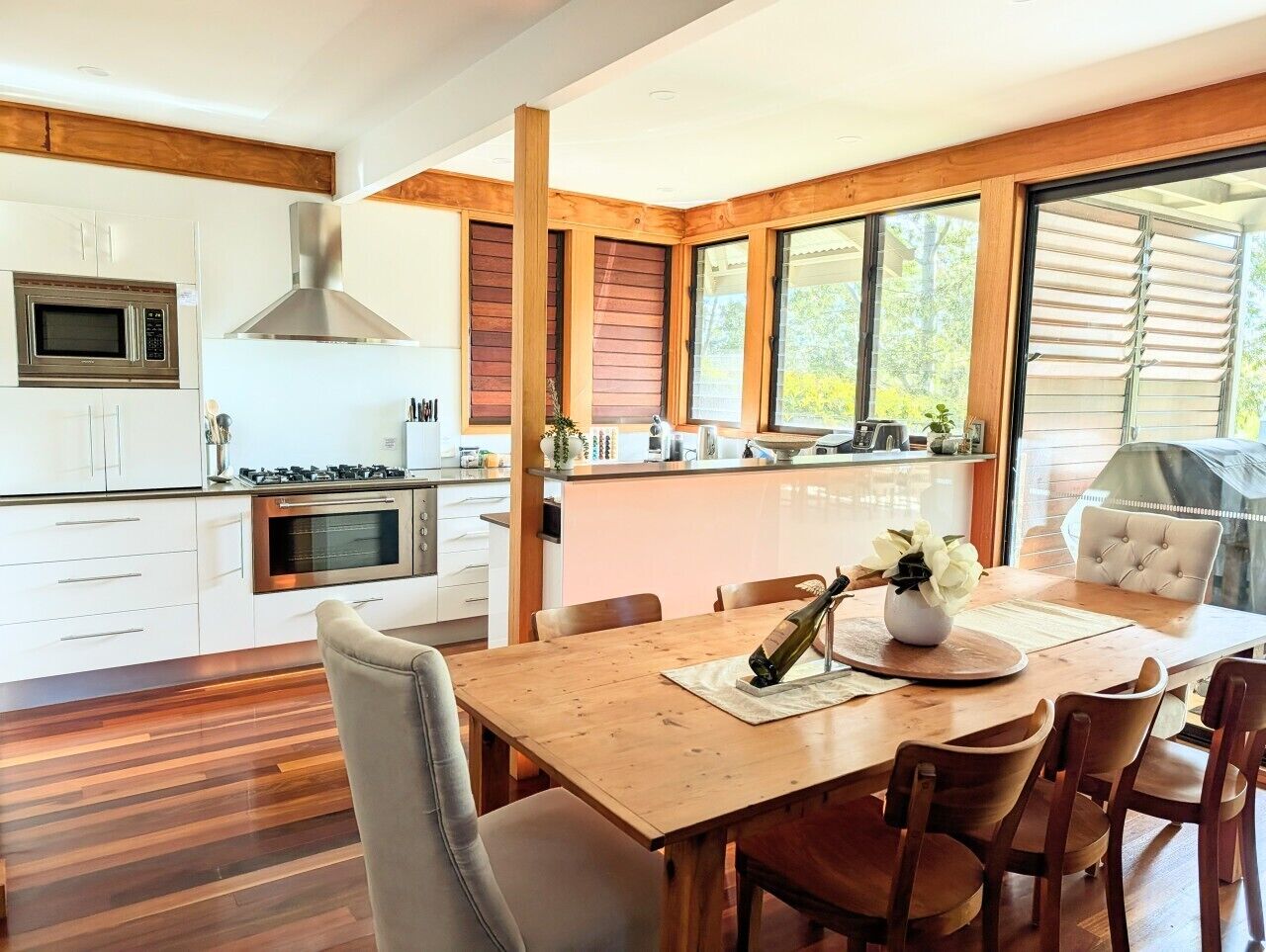 A modern kitchen with white cabinets, a built-in microwave, and a gas stove.
