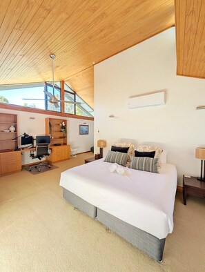 Ein modernes Schlafzimmer mit einem großen Bett, einem Schreibtisch und einem Stuhl.