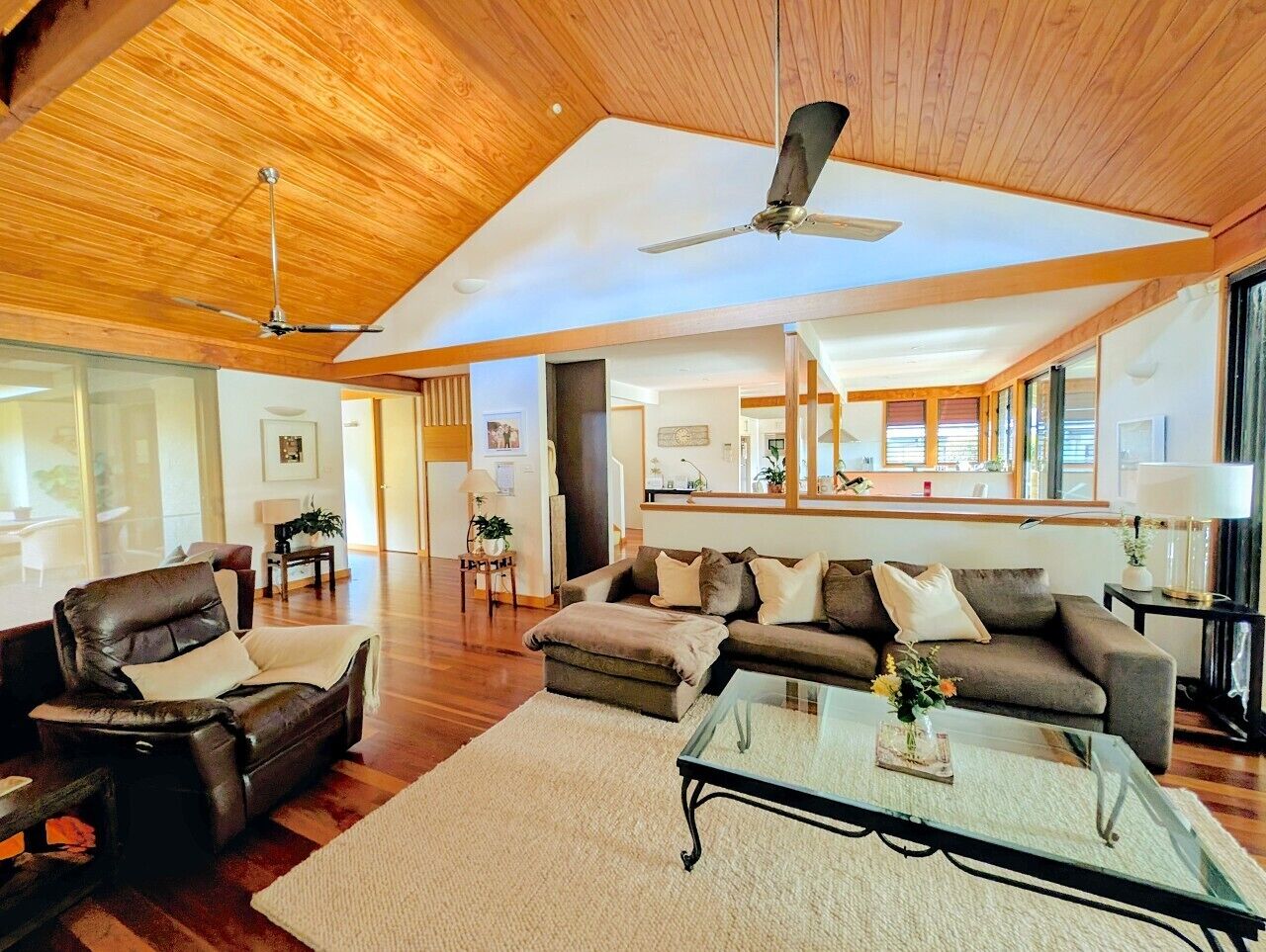Un salon spacieux doté d’un haut plafond, d’un ventilateur de plafond et d’une grande fenêtre laissant entrer la lumière naturelle.