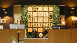 A reception area with a wooden desk, a computer, and a wall with wooden blocks spelling 'THE BLOCK HOTEL.' - Independent Boutique Hotel Suite Near Bentonville's Top Sights (Bentonville)