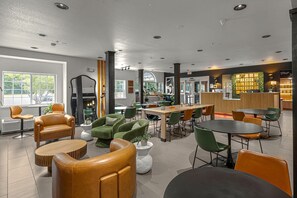 En modern hotellobby med en receptionsdisk, sittgrupper och utsikt över omgivningarna.