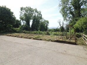 A paved road with a metal structure and trees in the background. - GULLANE EAST, with open fire in Rathmore, County Kerry (GNEEVEGUILLA)