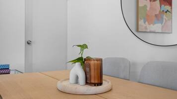 A wooden table with a white vase, a green plant, and a brown container.