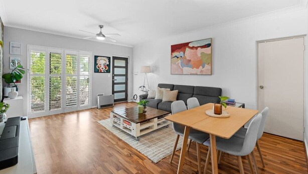 Una sala de estar moderna con sofá, mesa de centro, mesa de comedor y sillas.