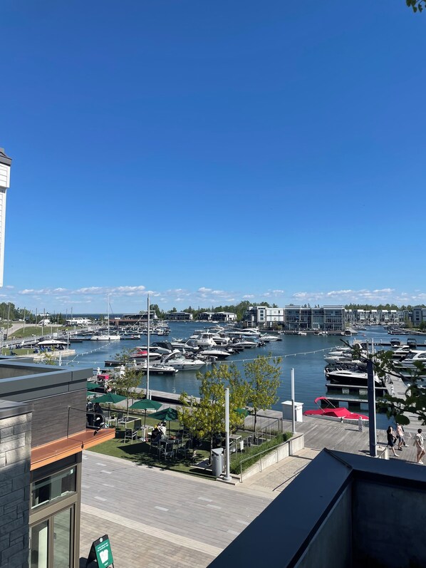 Un puerto deportivo con barcos amarrados, un cielo azul despejado y vistas de edificios a lo lejos.