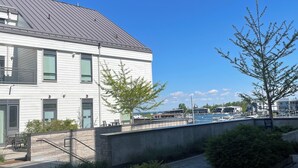 A modern building with a flat roof, large windows, and a paved area with planters. - FRIDAY HARBOUR CHIC WATERFRONT GETAWAY (Innisfil)