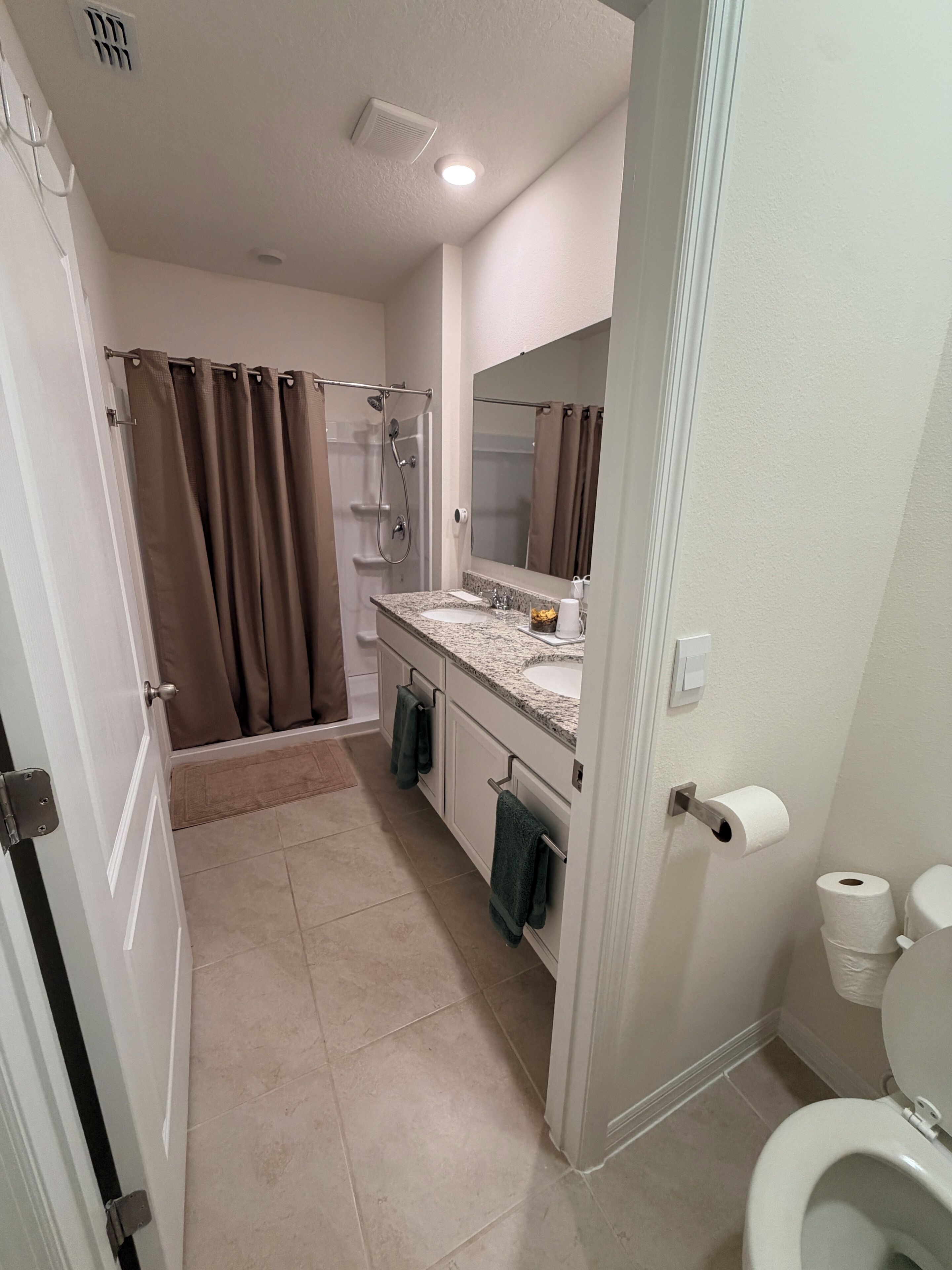 A bathroom with a shower, toilet, and sink.