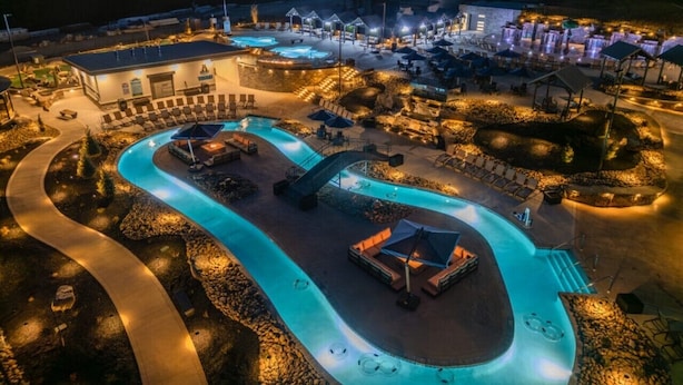Un complexe hôtelier doté d’une piscine sinueuse, d’un espace extérieur aménagé et d’un bâtiment à plusieurs étages.
