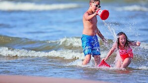 Deux enfants jouent dans l’eau sur la plage.