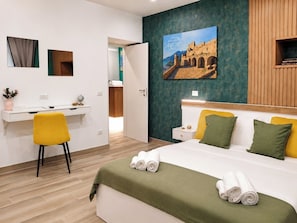Habitació d'hotel amb llit, escriptori i cadira.