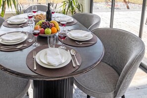 A round dining table set for four with a fruit bowl, wine glasses, and a bottle. - Skummeslöv Beach Home S, Skummeslövstrand, Sweden (Skummeslövstrand)