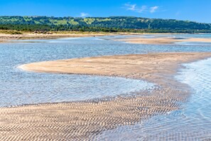 A beach with gentle waves, a sandy shore, and a backdrop of green hills. - Skummeslöv Beach Home S, Skummeslövstrand, Sweden (Skummeslövstrand)