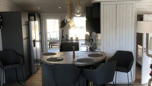 A modern kitchen with a central island, dark chairs, and a hanging light fixture. - Skummeslöv Beach Home S, Skummeslövstrand, Sweden (Skummeslövstrand)