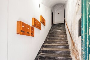 Eine Treppe mit an der Wand befestigten Briefkästen aus Holz.