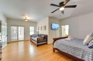 A bedroom with a bed, a ceiling fan, a TV, and a window. - Spacious Home-Game Room - Private Pond - Sleeps 16 (Midland)