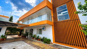 A modern building with a flat roof, a balcony, and a large window.