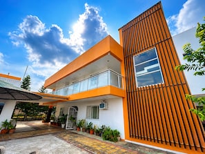 A modern building with a flat roof, a balcony, and a large window. - The Primrose Guesthouse Cavite (General Trias)