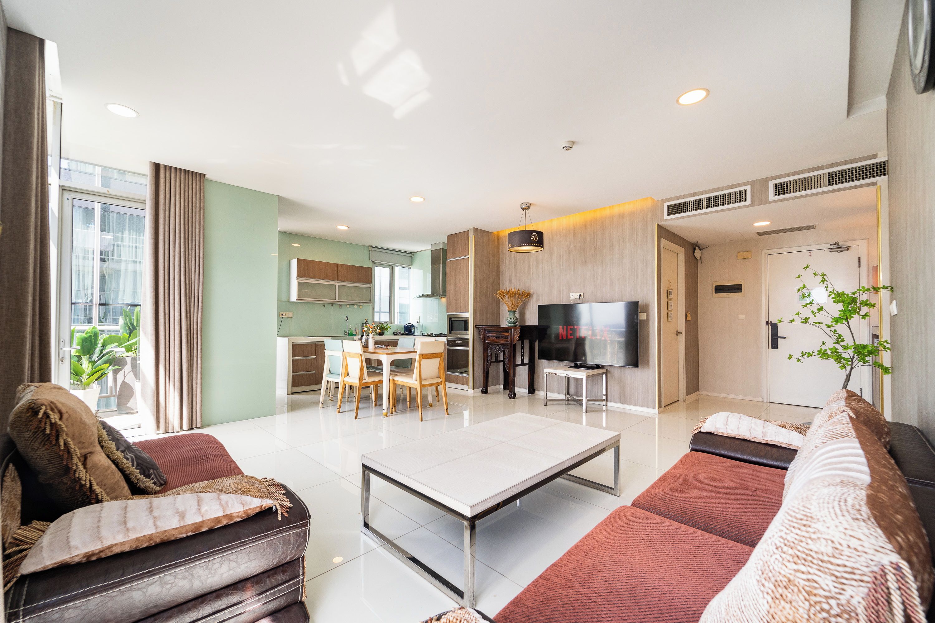 A modern living room with a sofa, a coffee table, and a television.