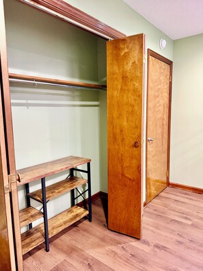 A walk-in closet with wooden shelves and a door. - Charming 3-bedroom rustic bungalow in tranquil Williamsburg sleeps 10 (Williamsburg)