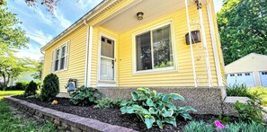Ein gelbes Haus mit Veranda, Briefkasten und gepflegtem Garten.