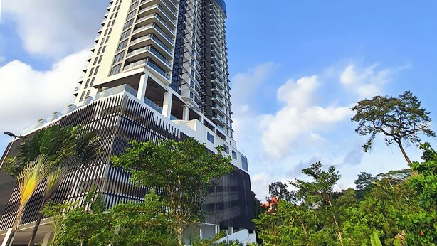 Um edifício alto e moderno, com fachada curva e varandas.