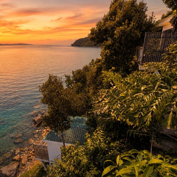 A coastal view with a pool, trees, and a building with a sloped roof. - The Cliff Bungalow (Koh Rong Sanloem)