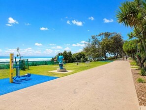 A park with exercise equipment, a walking path, and a view of the ocean. - Beachfront Ocean Views | Pools, Spa & Tennis (Gold Coast)