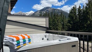 A hot tub on an outdoor deck with a mountain view.