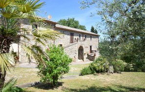 A stone building with a tiled roof, arched windows, and a small staircase leading to a porch. - Pet friendly home in Allerona (Allerona)