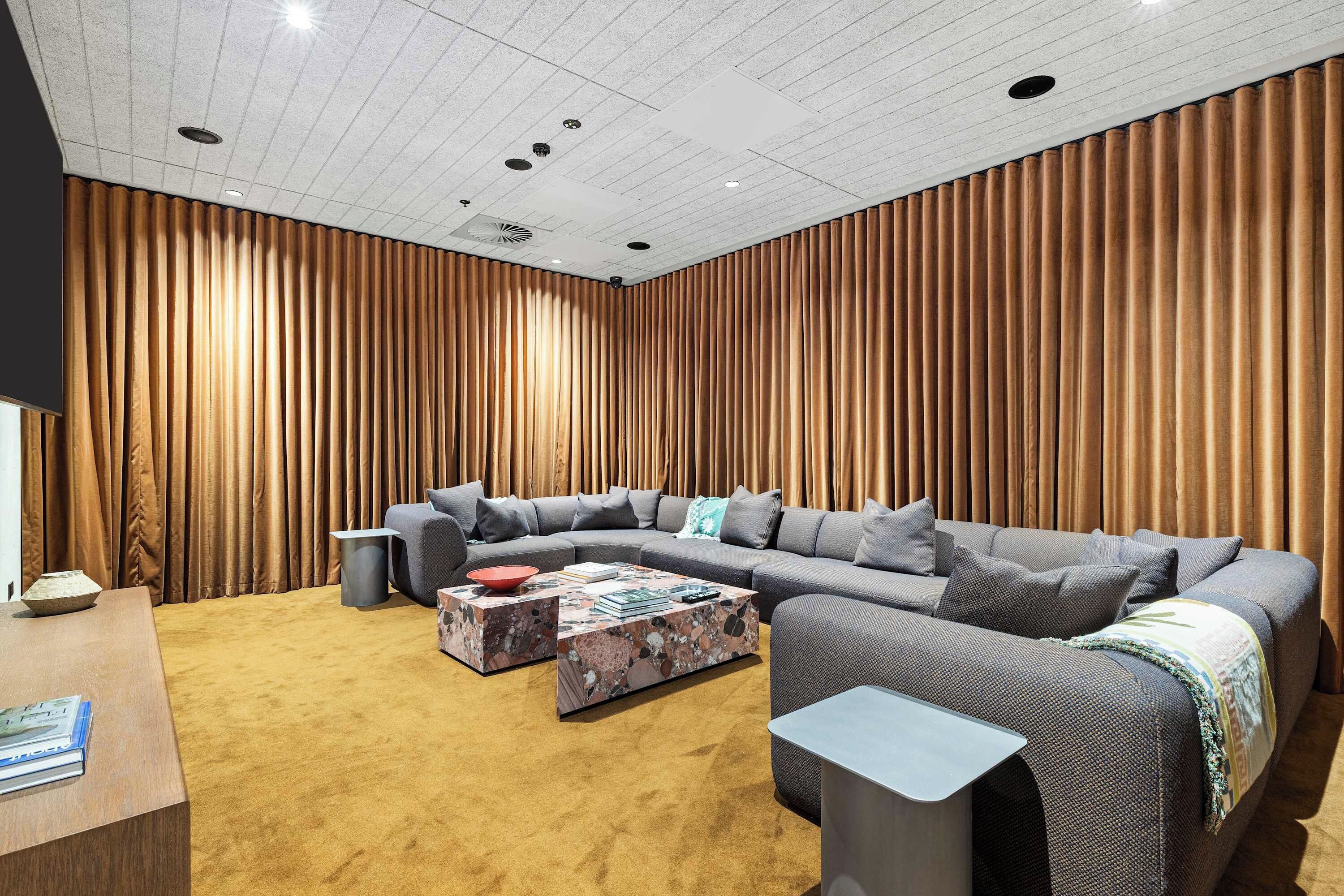 A modern living room with a sectional sofa, a coffee table, and a small side table.