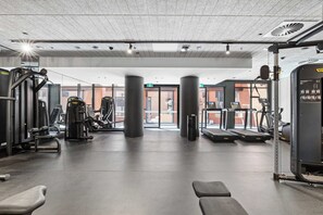 A gym with exercise equipment, a treadmill, and a trash bin. - Parkrise 902 | Modern Brunswick 2BR, 2 Bathrooms (Brunswick)