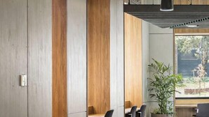 A modern office space with desks, chairs, and a large window. - Brunswick 2BR 2Bath w Free Parking + Park Views (Brunswick)