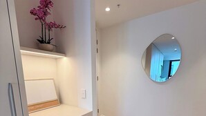 A hallway with a round mirror, a potted plant, and a small stool. - Brunswick 2BR 2Bath w Free Parking + Park Views (Brunswick)