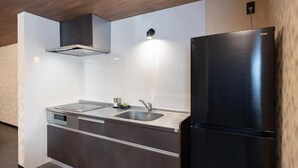 Eine moderne Küche mit einem schwarzen Kühlschrank, einer Edelstahl-Spüle und einem eingebauten Geschirrspüler.