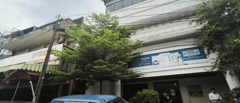 A building with a sign for 'YAM' and 'Stadio Hostel' advertising a price of IDR 125,000.