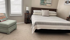 A bedroom with a bed, a chair, a nightstand, a lamp, and a painting on the wall. - Rest Ashore on the Sarasota Bay (Bradenton)