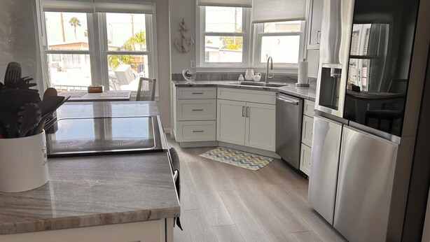 A modern kitchen with a large island, stainless steel appliances, and a view of the outdoors. - Rest Ashore on the Sarasota Bay (Bradenton)