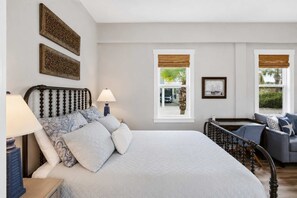 A bedroom with a bed, bedside lamps, a window with a view, and a balcony. - New St George Island Retreat  Pool Pet Friendly (Saint George Island)