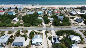 Luftaufnahme einer Küstenwohngegend mit Häusern, Straßen und einem Strand.