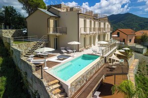 Ein mehrstöckiges Gebäude mit Swimmingpool, Außenbereich und Bergblick.