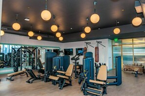 A gym with exercise equipment, mirrors, and hanging lights. - The Gallery | Lux Studio in Wynwood (Miami)